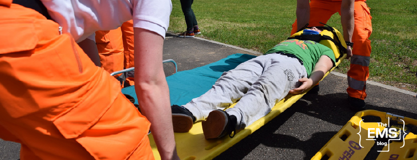 rettungskräfte-tragen-einen-patienten-auf-einer-trage-im-freien