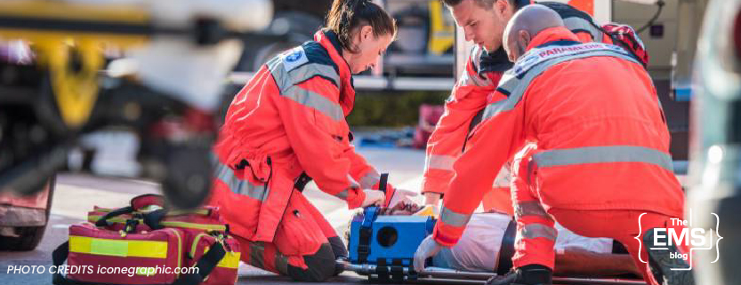 équipe-de-secours-en-tenue-rouge-prodiguant-des-soins-à-un-patient-allongé-sur-le-sol