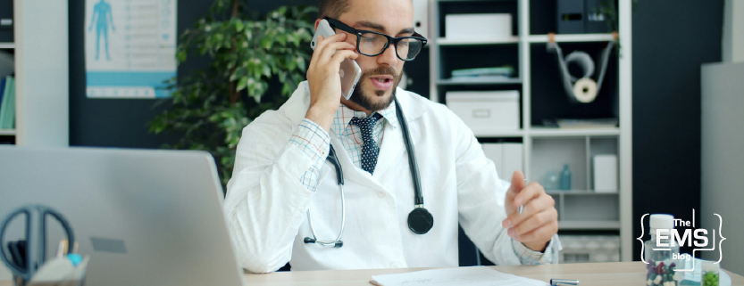 arzt-im-sprechstundenraum-telefoniert-und-arbeitet-am-laptop-im-medizinischen-umfeld
