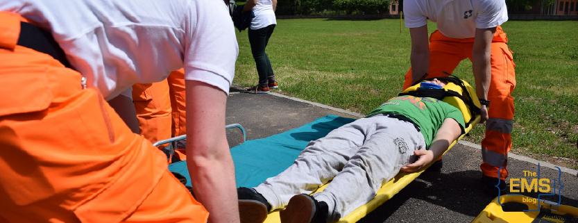 des-intervenants-transferent-un-patient-immobilise-sur-un-brancard-spinal-lors-dun-exercice-en-exterieur