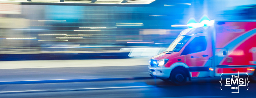 red-ambulance-driving-along-an-urban-road-with-its-blue-emergency-lights-flashing